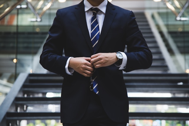 A Person in a Stylish Suit in Front of Stairs
